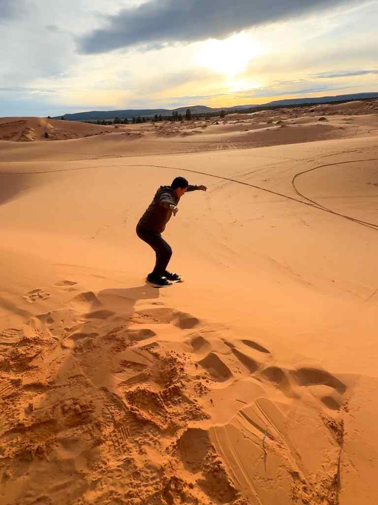 Sandboarding down the Coral Pink Sand Dunes