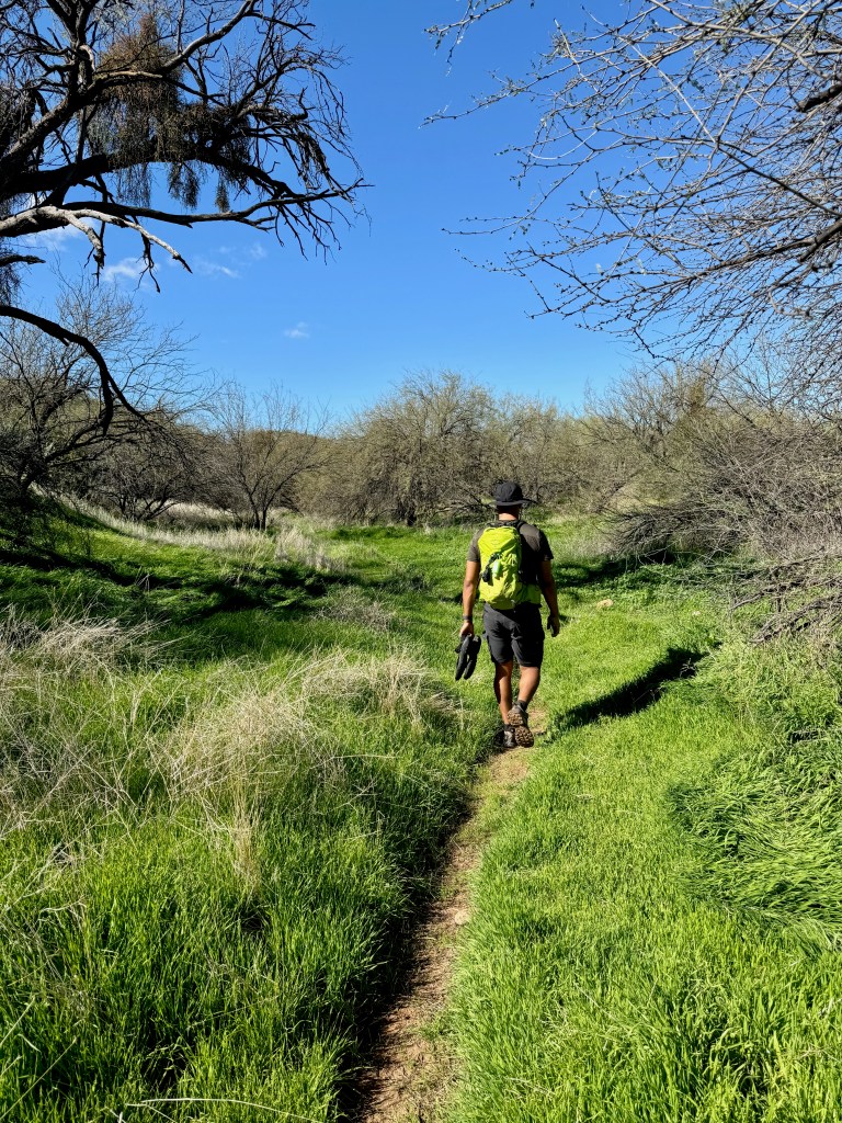 Owen hiking with Teva Sandals in hand after crossing the river